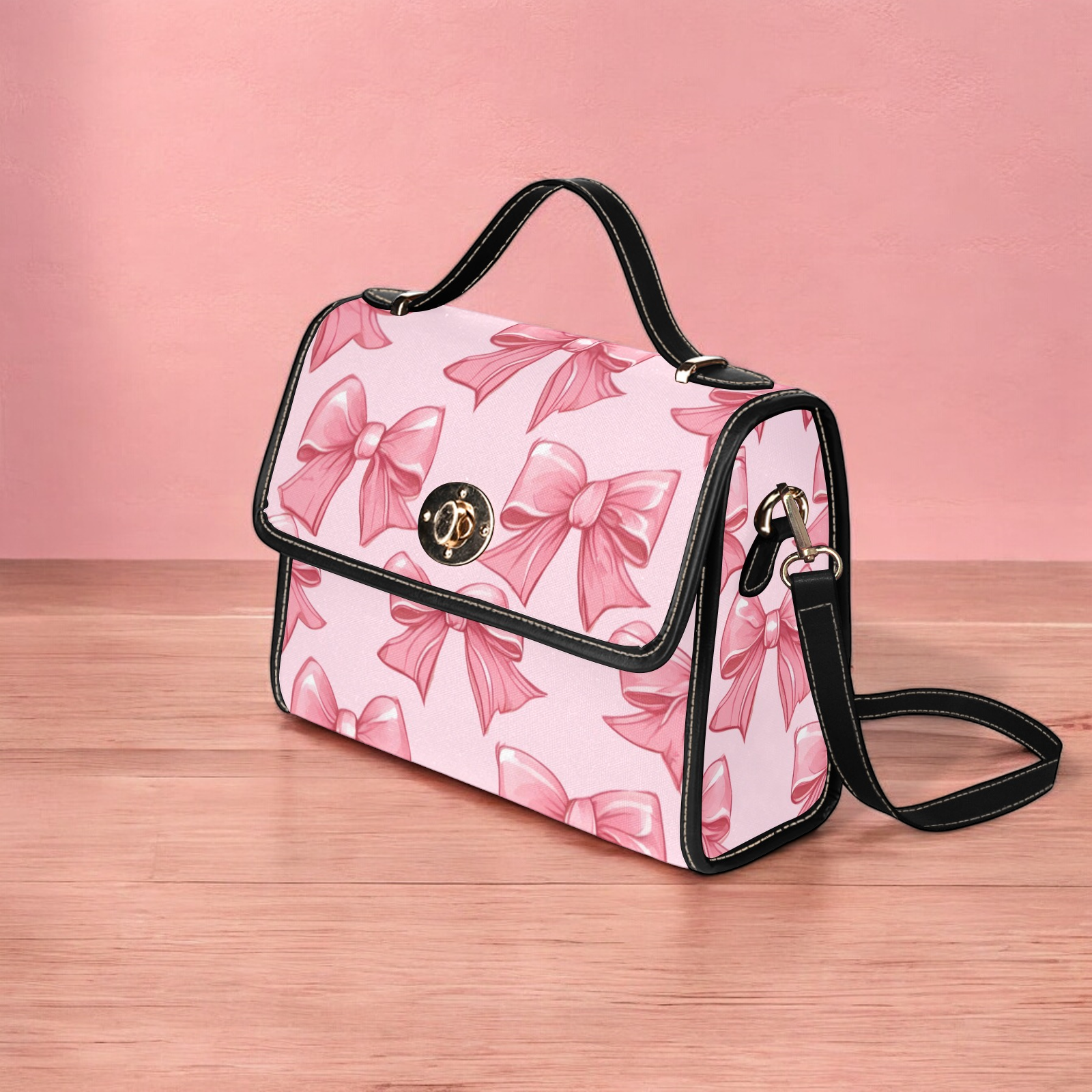 a pink and black handbag with bows on it